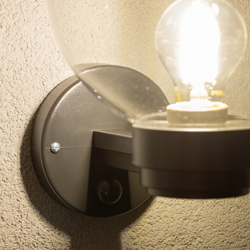 BRILAGI - Utomhusvägglampa med rörelsesensor HARBOR 1xE27/40W/230V IP33 svart/klarglas